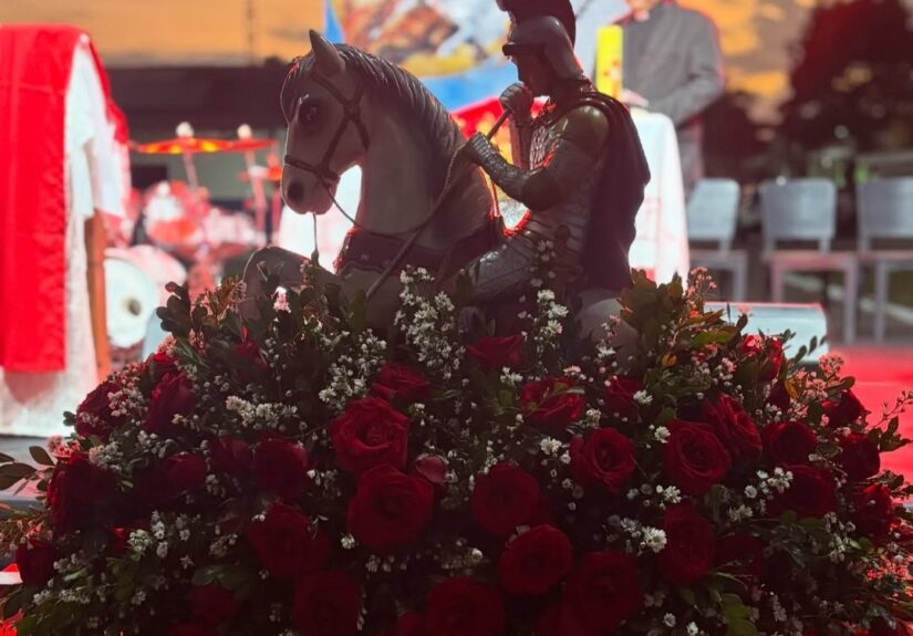 Imagem de São Jorge durante a celebração no 20º BPM, com flores vermelhas que simbolizam fé e devoção — Foto: Reprodução/Instagram (@20bpm_pmerj)
